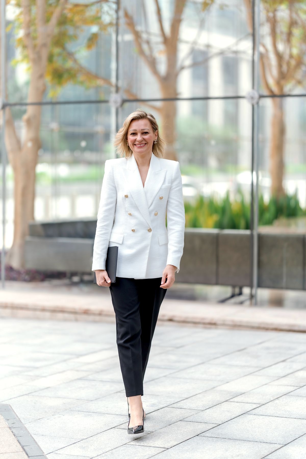 Sofia Borodulina-Abboud walking outside a glass office building in Abu Dhabi